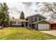 Charming two-story gray home with manicured lawn, landscaping, and attached garage at 8370 E Princeton Ave, Denver, CO 80237