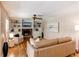 Inviting living room features a cozy fireplace, built-in shelving, and wood flooring at 8370 E Princeton Ave, Denver, CO 80237