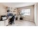 Spacious home office with dual desk setups, wood-look flooring, bright window and ample storage at 8370 E Princeton Ave, Denver, CO 80237