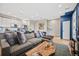 Living room with hardwood floors, gray sofa, kitchen view, and modern decor at 1302 N Stuart St, Denver, CO 80204