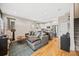 Open-concept living room and kitchen with hardwood floors, modern furnishings, and stainless steel appliances at 1302 N Stuart St, Denver, CO 80204