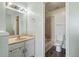 View into the bathroom featuring neutral cabinets, an updated mirror, and tub-shower combo at 10731 W 63Rd Ave # A, Arvada, CO 80004