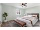 This staged bedroom features an upholstered headboard and bench with fresh light-green paint at 10731 W 63Rd Ave # A, Arvada, CO 80004