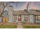 Charming townhome featuring light gray siding, red front door, chimney and lovely landscaping at 10731 W 63Rd Ave # A, Arvada, CO 80004