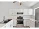 Kitchen with white cabinets, stainless steel appliances, marble counters, and undermount sink at 10731 W 63Rd Ave # A, Arvada, CO 80004