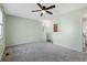 Bright main bedroom with an ensuite bathroom, ceiling fan, and neutral carpeting at 10731 W 63Rd Ave # A, Arvada, CO 80004