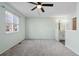 Spacious main bedroom featuring a ceiling fan, a view into an ensuite bathroom, and fresh light-green paint at 10731 W 63Rd Ave # A, Arvada, CO 80004