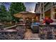 Evening view of backyard patio with stone seating and umbrella at 5458 W Calhoun Ave, Littleton, CO 80123