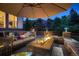 Relaxing backyard patio with fire pit, seating area, and umbrella at 5458 W Calhoun Ave, Littleton, CO 80123