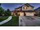 Two-story house with stone accents, three-car garage, and landscaped lawn at 5458 W Calhoun Ave, Littleton, CO 80123