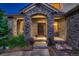 Stone facade entryway with double doors, lighted at night, and lush landscaping at 5458 W Calhoun Ave, Littleton, CO 80123