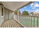 Balcony with a view of the community tennis court, surrounded by trees and blue sky at 910 S Walden St # 201, Aurora, CO 80017