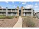 Exterior view of the building with stone accents, balconies, and a landscaped walkway at 910 S Walden St # 201, Aurora, CO 80017