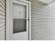 Close-up of the white front door with a storm door and siding at 910 S Walden St # 201, Aurora, CO 80017
