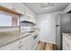 Bright kitchen features white appliances, granite countertops, and wood-style flooring for a modern aesthetic at 910 S Walden St # 201, Aurora, CO 80017