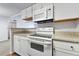 A bright kitchen showcasing white cabinets, stone countertops, and modern appliances including an oven and microwave at 910 S Walden St # 201, Aurora, CO 80017