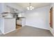 Bright living room with plush carpeting open to a functional kitchen with white cabinets and granite countertops at 910 S Walden St # 201, Aurora, CO 80017