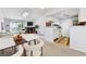 Cozy living room featuring a stone fireplace, natural light, and an adjacent modern kitchen with white cabinets at 910 S Walden St # 201, Aurora, CO 80017