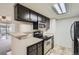 Modern kitchen featuring stainless steel appliances, stone countertops, and dark wood cabinets at 4400 S Quebec St # D203, Denver, CO 80237