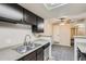 Well-lit kitchen featuring dark cabinetry, modern appliances, and an open layout to the dining area at 4400 S Quebec St # D203, Denver, CO 80237