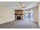 Spacious living room with neutral carpet, a stone fireplace, and access to the private outdoor balcony at 4400 S Quebec St # D203, Denver, CO 80237
