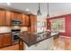 Well-equipped kitchen with stainless steel appliances, granite countertops, and a dining area at 11962 W Long Cir # 103, Littleton, CO 80127