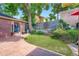 Landscaped backyard featuring a brick building, small grass lawn, and brick patio at 3530 E 8Th Ave, Denver, CO 80206