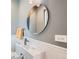Modern half-bathroom with a sleek round mirror, stylish fixtures, and clean white subway tile detailing at 3530 E 8Th Ave, Denver, CO 80206