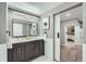 Bathroom with dual vanity, modern lighting, and a glimpse of the bedroom through a sliding door at 3530 E 8Th Ave, Denver, CO 80206