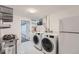 A clean laundry room with modern washer, dryer, and organized storage at 3530 E 8Th Ave, Denver, CO 80206