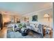Comfortable living room featuring a large sectional sofa, round coffee table, and stylish decor at 3530 E 8Th Ave, Denver, CO 80206