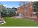 Spacious backyard with a manicured lawn, mature trees and brick patio at 35 S Albion St, Denver, CO 80246