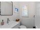 Bright bathroom features a modern sink, decorative window, and white tiling halfway up the wall at 35 S Albion St, Denver, CO 80246