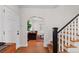 Bright entryway featuring hardwood floors, staircase with dark banister, and views into a cozy living space at 35 S Albion St, Denver, CO 80246