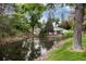Exterior view of the property, showing the surrounding trees, pond, and unique architectural design at 7925 W Layton Ave # 605, Littleton, CO 80123