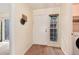 Bright foyer featuring wood-look floors, a window that lets in natural light, and a view to the laundry closet at 7925 W Layton Ave # 605, Littleton, CO 80123