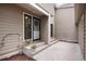 Exterior view of home's front entrance featuring a secure, gated door, flower pots, and a concrete porch at 7925 W Layton Ave # 605, Littleton, CO 80123