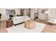 Open-concept living room with hardwood floors, stylish furniture, and an adjacent staircase leading to the upper level at 7925 W Layton Ave # 605, Littleton, CO 80123