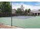Community tennis court surrounded by a green fence and trees providing an active lifestyle at 7925 W Layton Ave # 605, Littleton, CO 80123