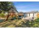 Spacious backyard with lush lawn, custom play structure, patio, and attractive landscaping at 8242 E Briarwood Pl, Centennial, CO 80112