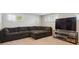 Basement entertainment area with large sectional sofa and a large screen TV at 8242 E Briarwood Pl, Centennial, CO 80112