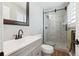 Updated bathroom features a quartz countertop, wood-look floors, and a modern glass shower at 8242 E Briarwood Pl, Centennial, CO 80112