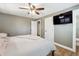 Well lit bedroom featuring ceiling fan, television, and an ensuite bathroom at 8242 E Briarwood Pl, Centennial, CO 80112