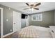 Relaxing bedroom with ceiling fan, mounted television, and white interior doors and trim at 8242 E Briarwood Pl, Centennial, CO 80112