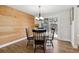 Cozy dining room featuring wooden accent wall and sliding glass door to the outdoors at 8242 E Briarwood Pl, Centennial, CO 80112