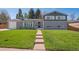 Beautiful two-story home features a brick facade, well-manicured lawn, and inviting front entrance at 8242 E Briarwood Pl, Centennial, CO 80112