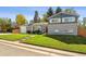 Charming two-story home with a brick exterior, green lawn, and tasteful landscaping enhances curb appeal at 8242 E Briarwood Pl, Centennial, CO 80112