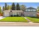 Beautiful two-story home featuring a green lawn, mature trees, and welcoming front porch at 8242 E Briarwood Pl, Centennial, CO 80112