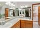 Bathroom featuring dual sinks with oak cabinets and a large mirror at 8220 S Brentwood St, Littleton, CO 80128