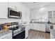 Modern white kitchen with stainless steel appliances and granite countertops with a view to backyard at 9471 Ashbury Cir # 202, Parker, CO 80134